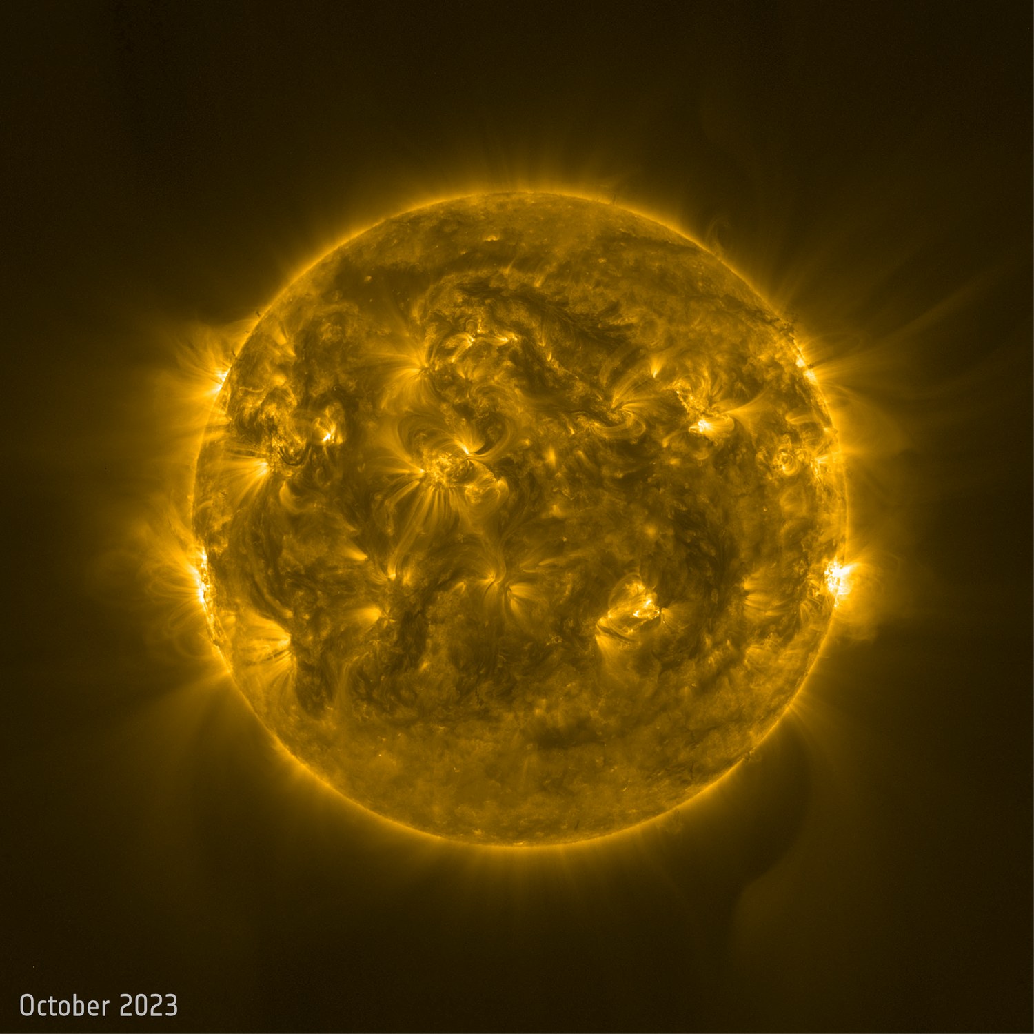 Solar Orbiter view of increased solar activity, with bright coronal structures and dark sunspots.